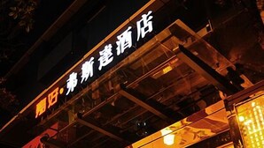 A hotel with a modern glass facade and a sign in Chinese characters. - Xiao Jia He (Chengdu)