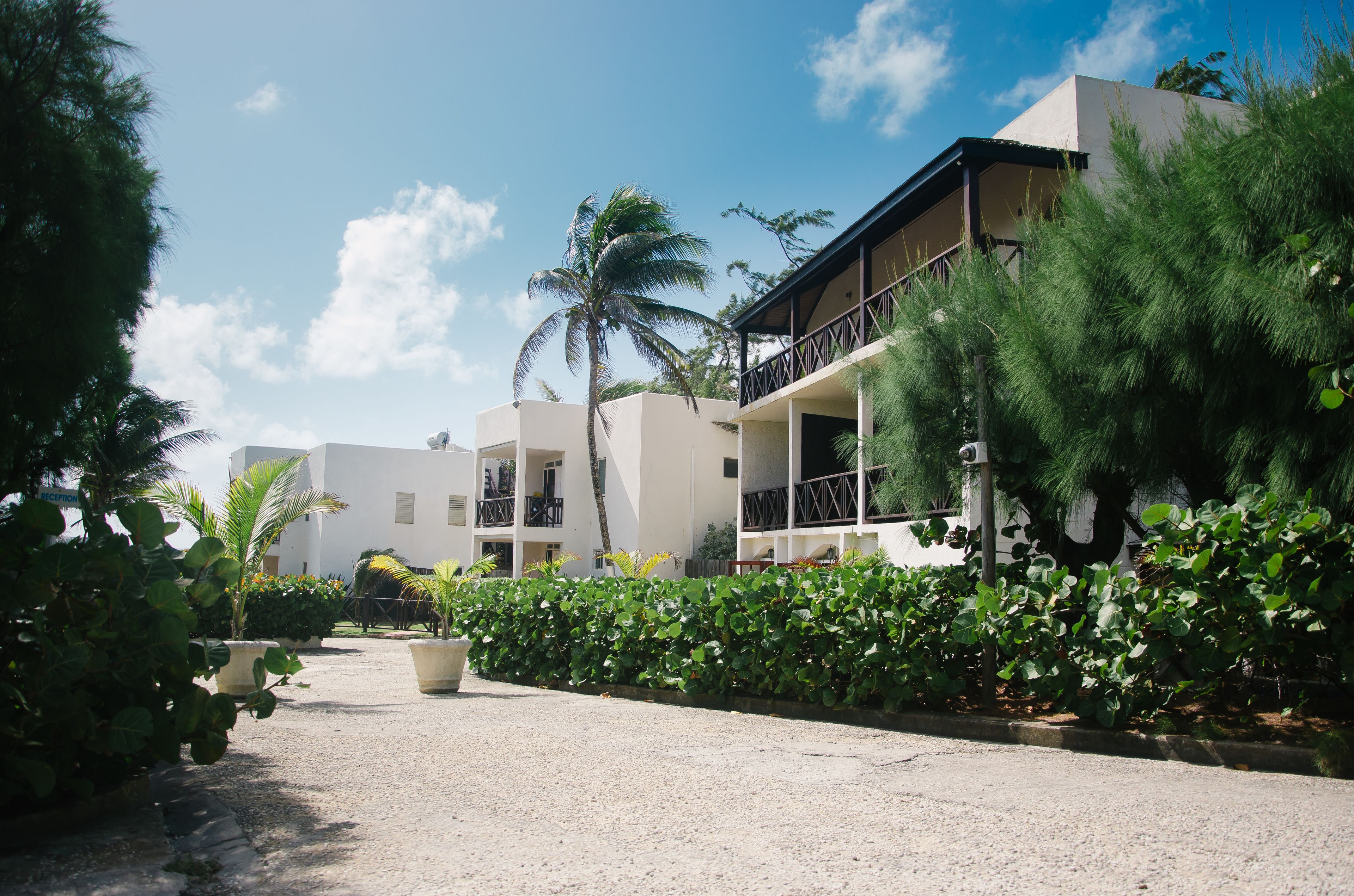 A resort with multiple-story buildings, outdoor seating areas, and lush greenery.