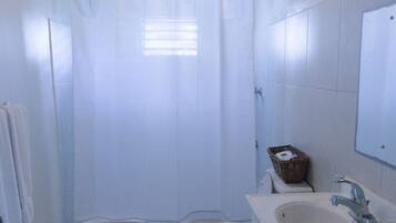 A small bathroom with a toilet, sink, and shower curtain.