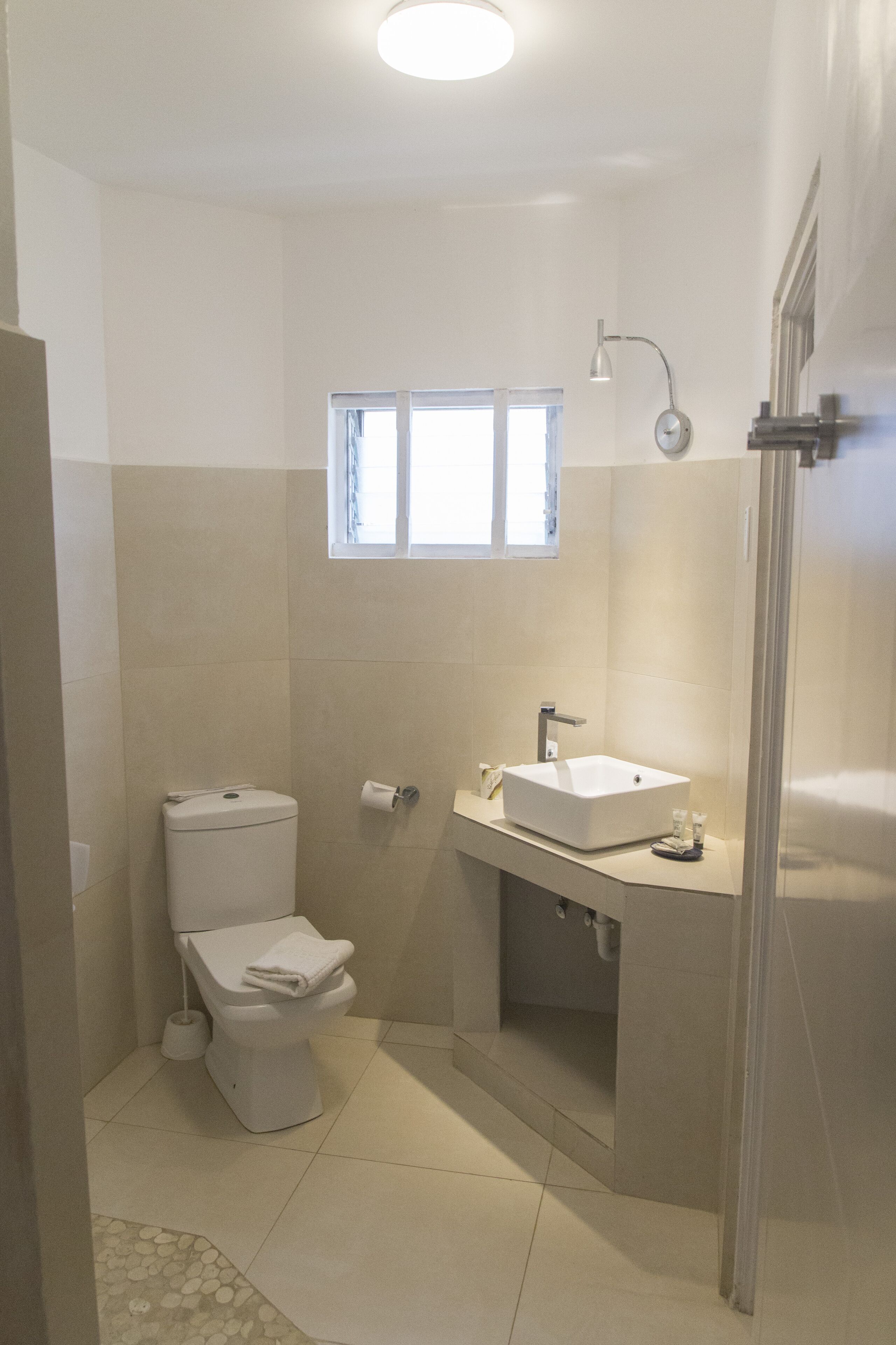 A bathroom with a toilet, sink, and shower.