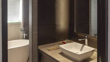 A modern bathroom with a freestanding bathtub, a large mirror, and a vanity with a sink.