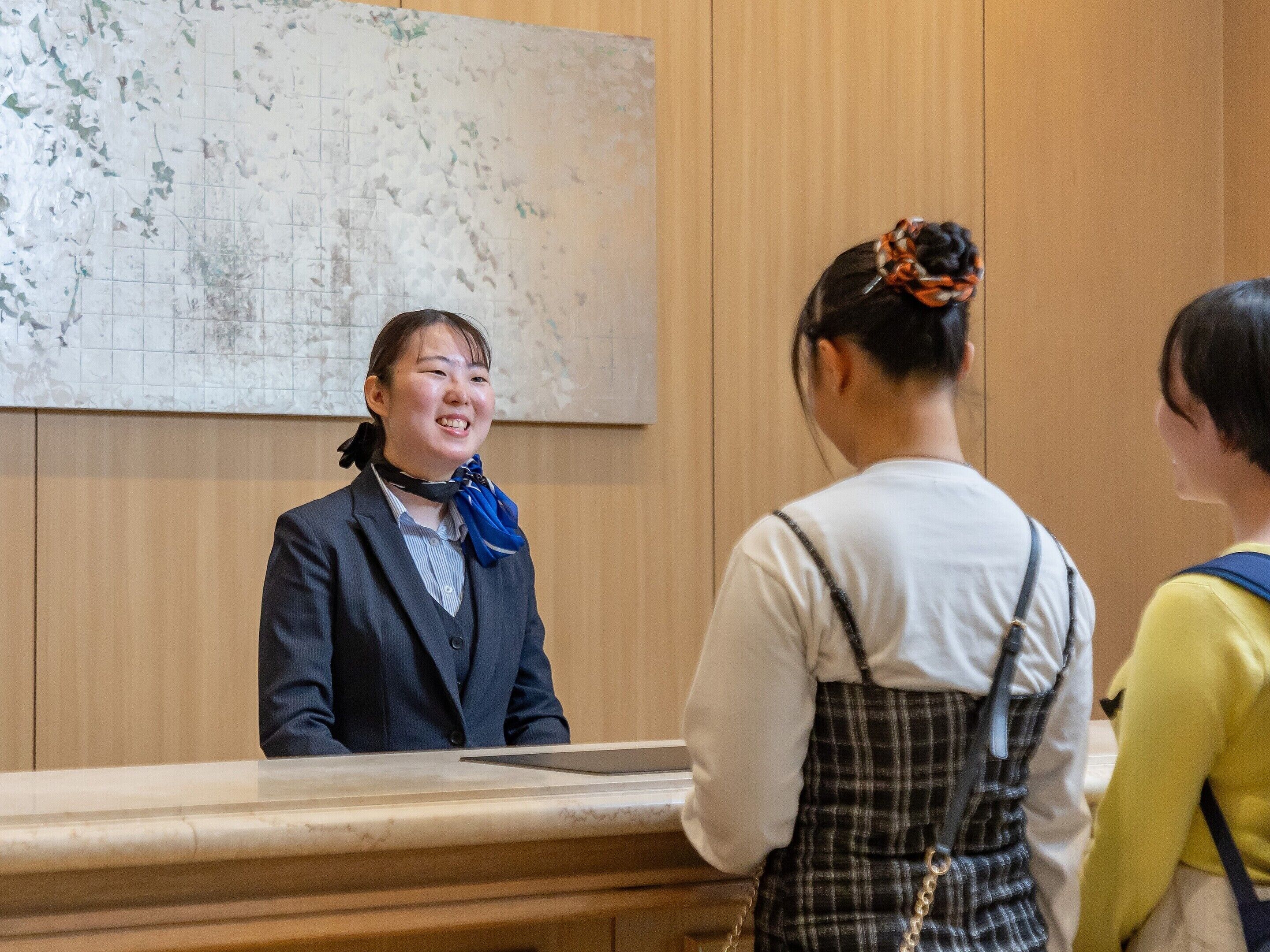 A reception area with a marble counter, wooden paneling, and a large map on the wall.