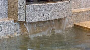A water feature with a stone basin and a small shelf.