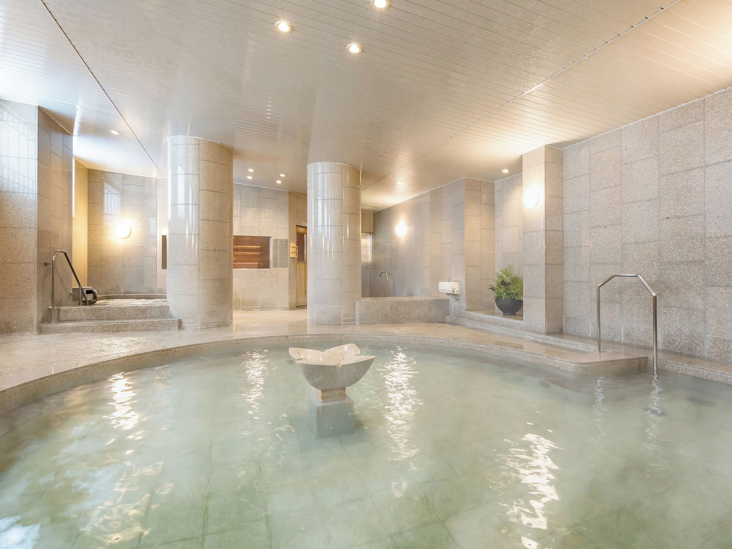 A spa area with a hot tub, stone columns, and a reception desk.