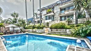A modern hotel with a swimming pool, lush greenery, and a multi-story building with balconies. - Colombe Hotel Boutique (Xalapa)