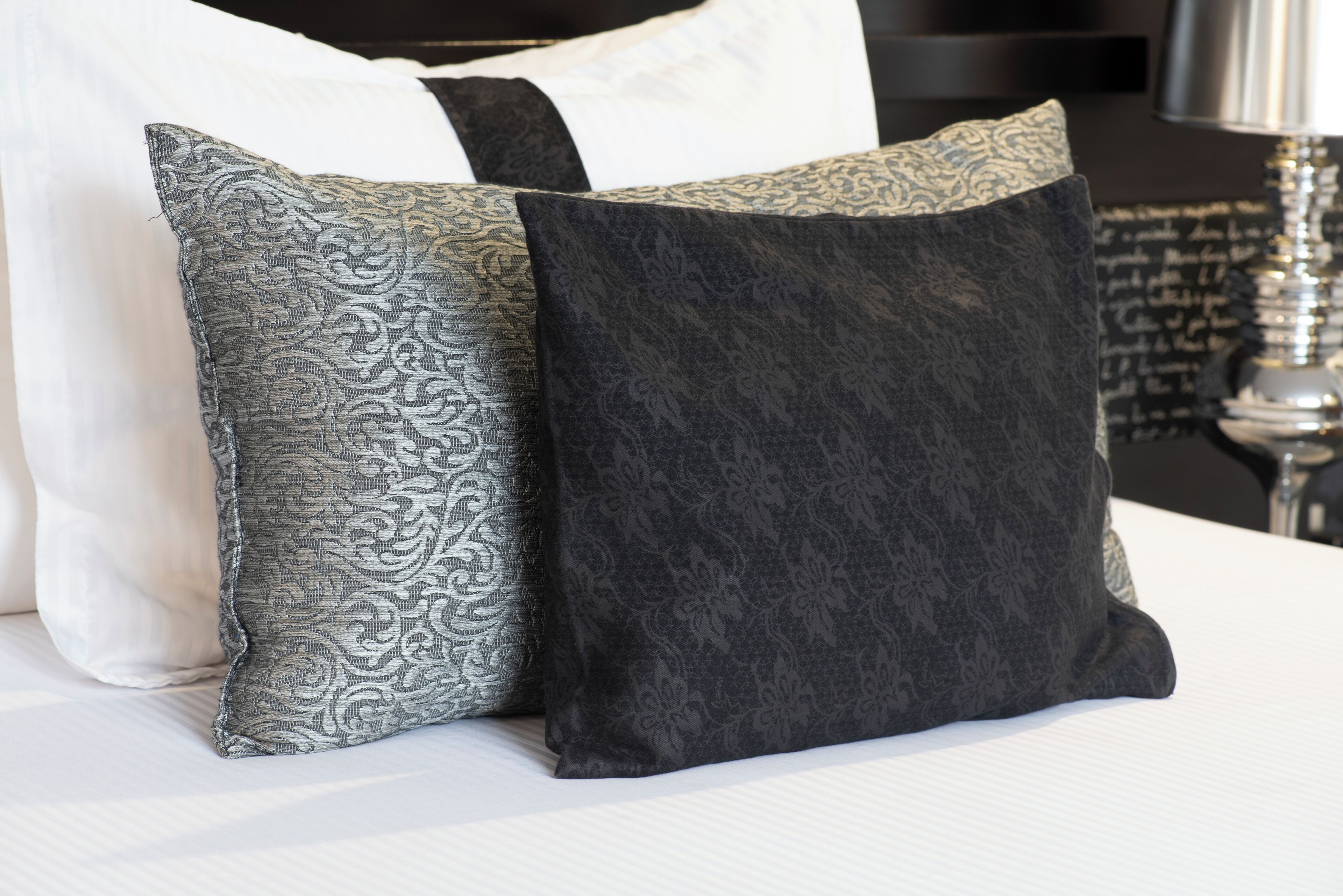 Two pillows with intricate patterns on a bed.