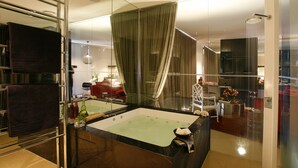 A modern bathroom with a large bathtub, a glass shower enclosure, and a glass partition. - Hepburn at Hepburn (Hepburn Springs)