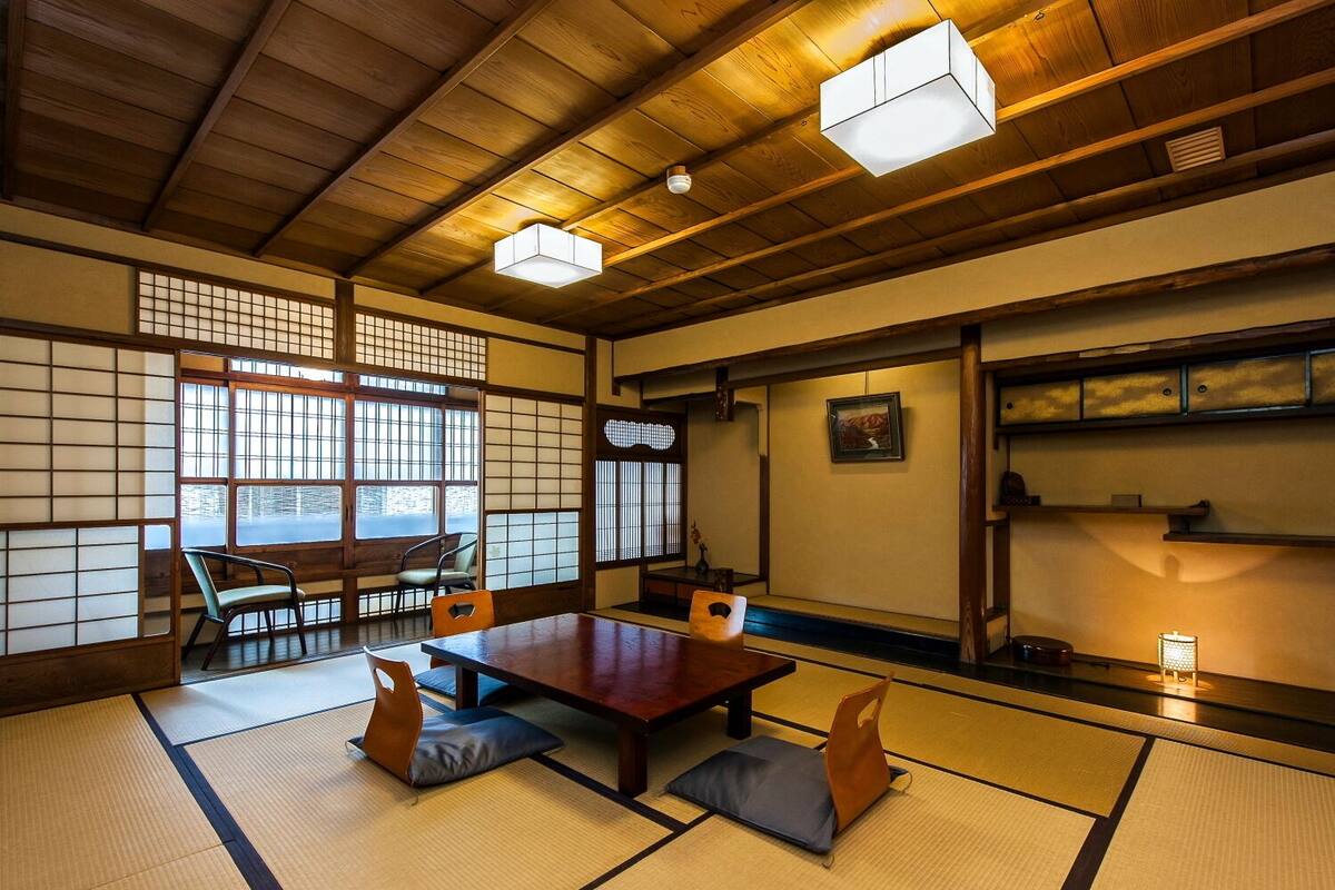 A traditional Japanese room with tatami flooring, a low wooden table, and sliding doors.