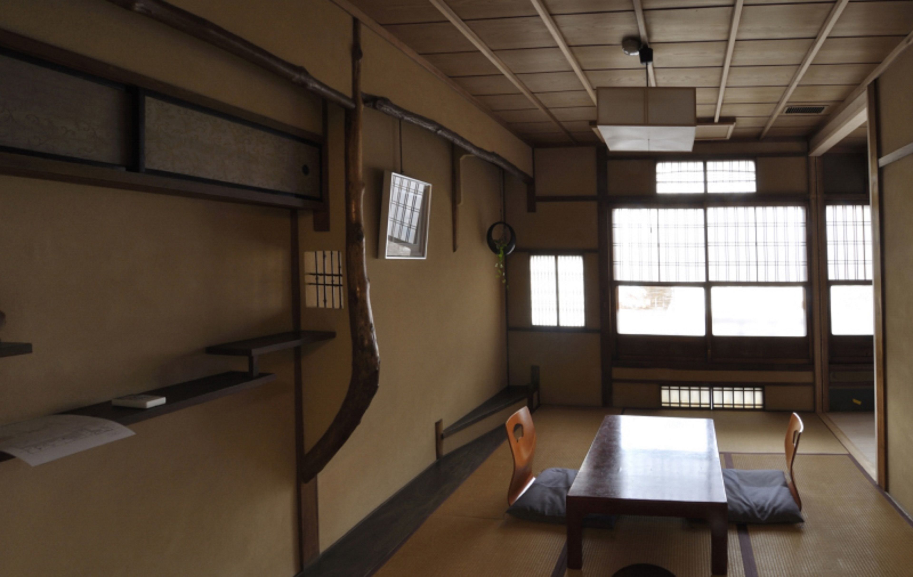 Una habitación japonesa tradicional con suelo de tatami, una mesa baja y puertas correderas.