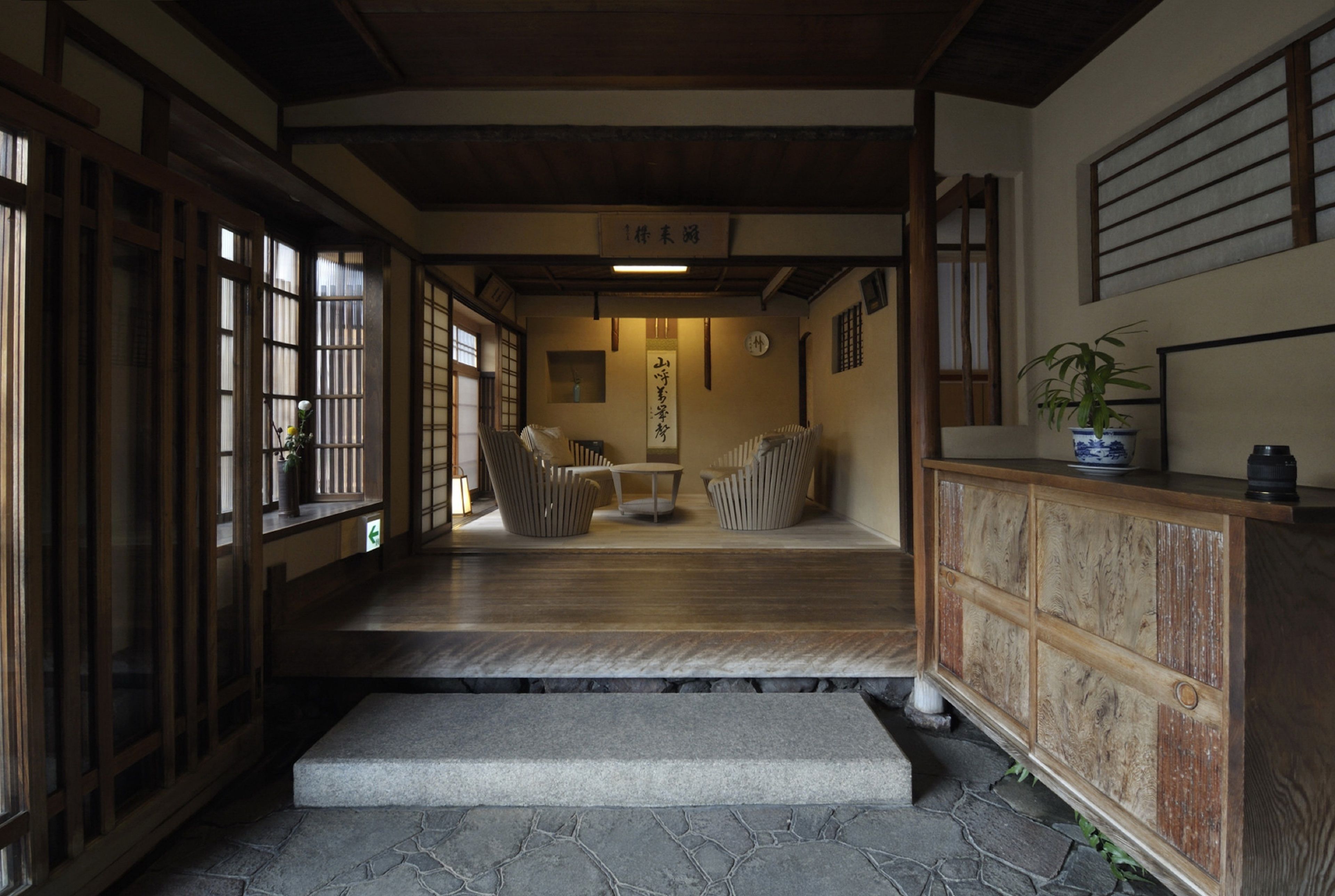 A traditional Japanese interior with tatami flooring, sliding doors, and a low wooden table with cushions.