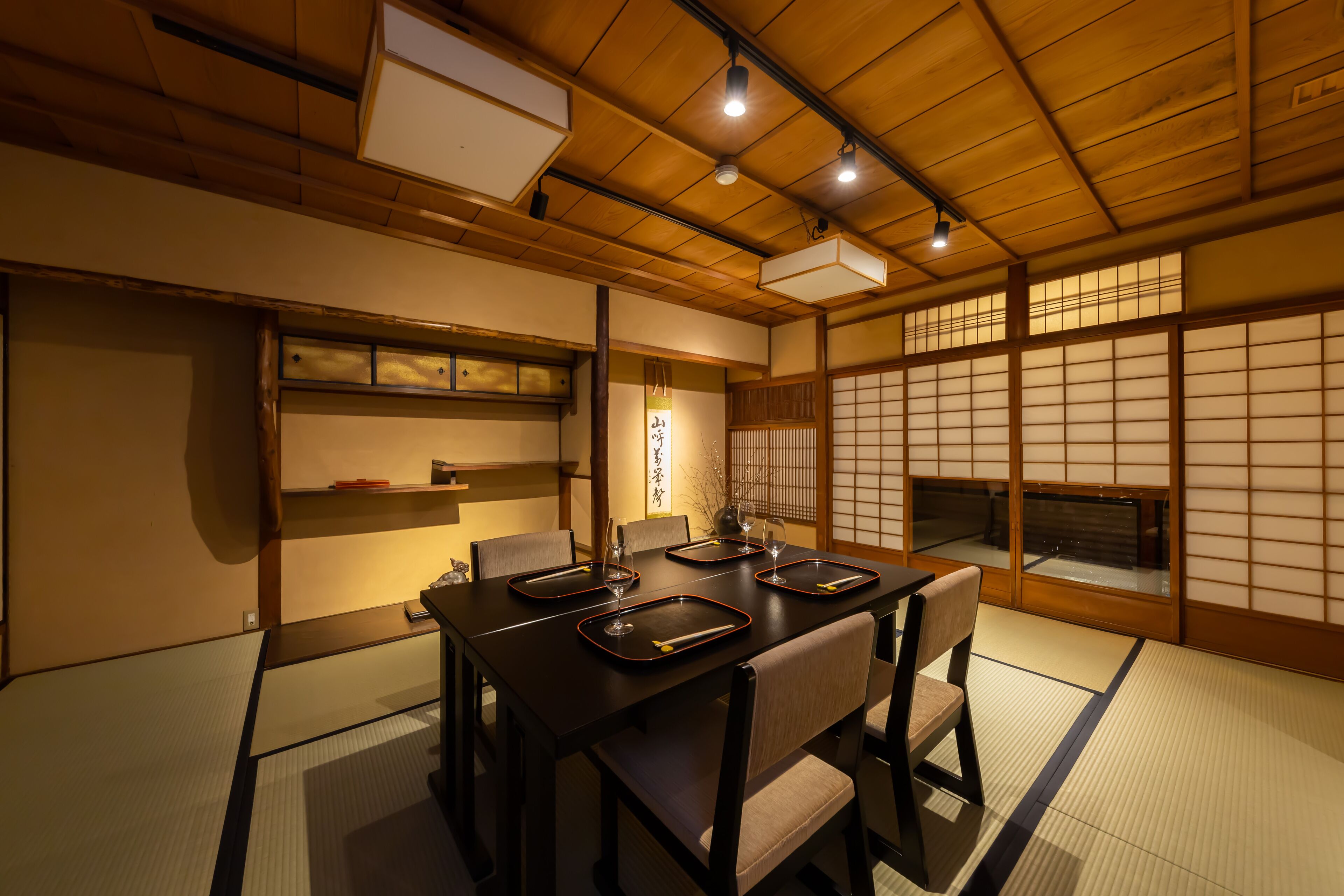 A traditional Japanese-style room with tatami flooring, a low table with chopsticks, and sliding doors.