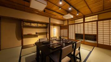 A traditional Japanese-style room with tatami flooring, a low table with chopsticks, and sliding doors.