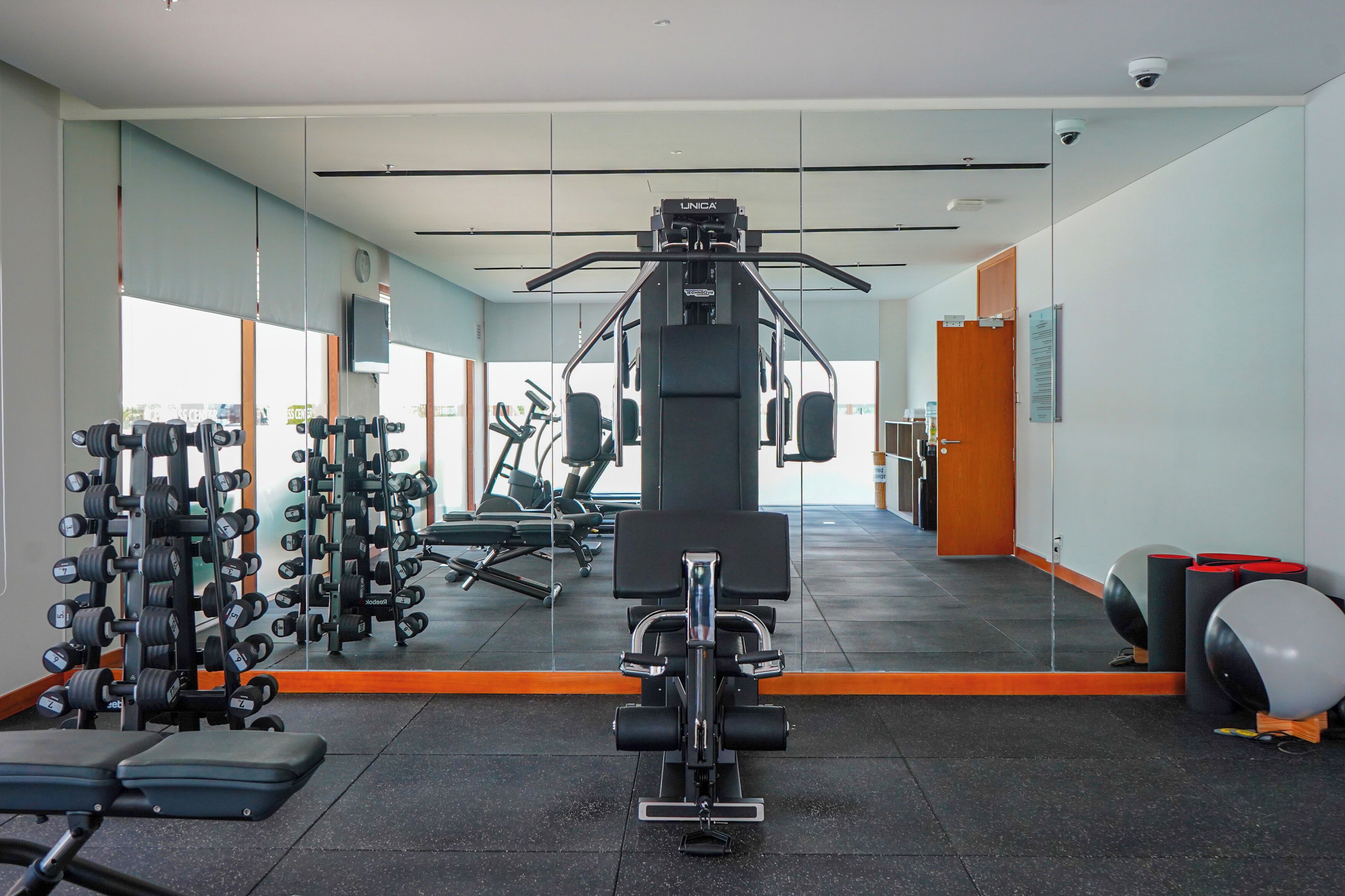 A gym with weightlifting equipment, treadmills, and exercise balls.