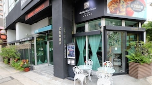 A hotel exterior with a glass entrance, outdoor seating, and a sign for a bridal tea house. - Bridal Tea House Hung Hom Gillies Avenue South (Kowloon)
