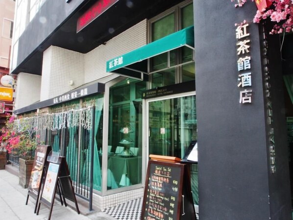 A hotel exterior with a sign indicating a restaurant and a tea house.