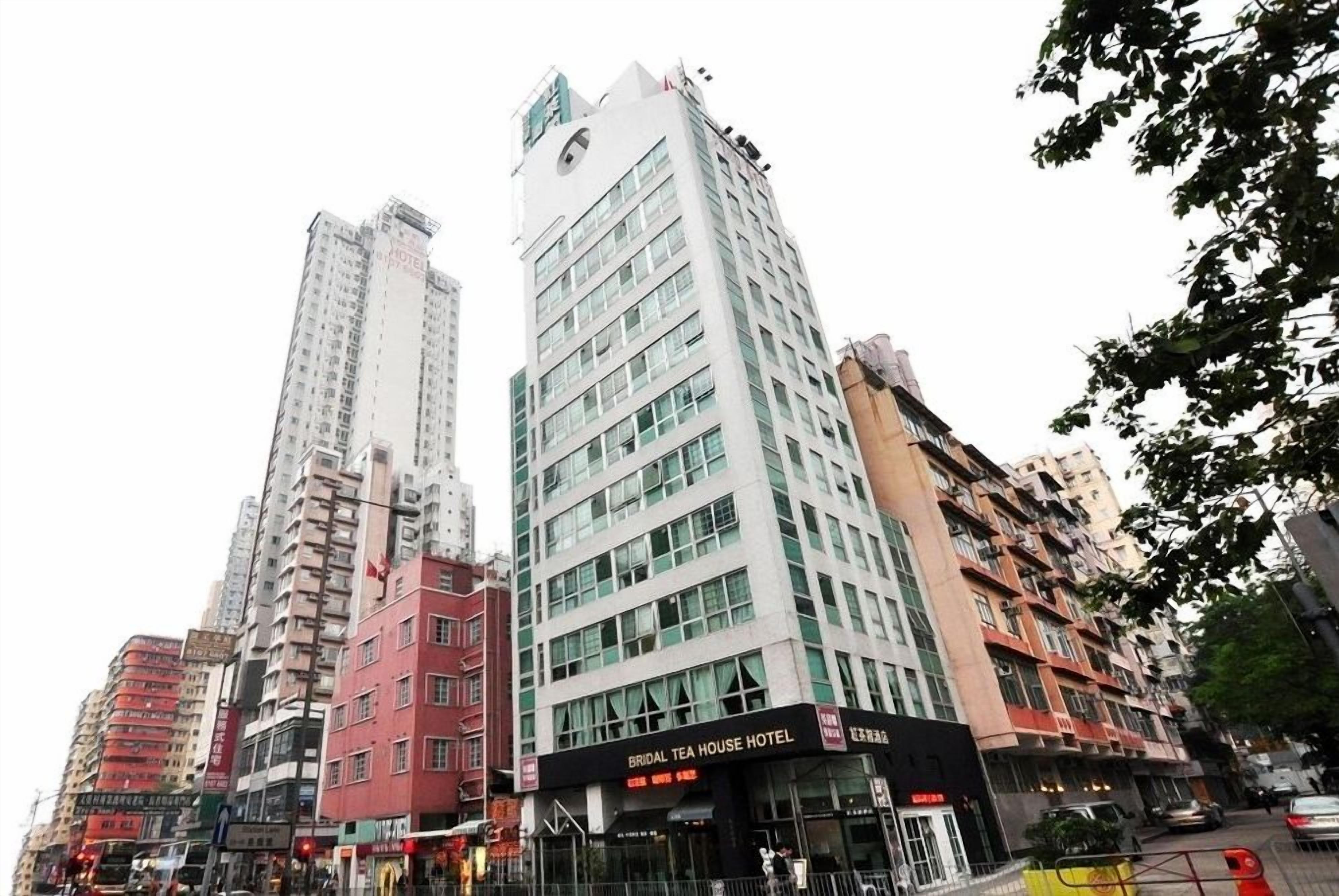 A hotel with a sign reading 'BRIDAL TEA HOUSE HOTEL,' surrounded by high-rise buildings.
