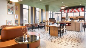 Un restaurant moderne doté d’un bar, d’un espace pour s’asseoir et de décorations murales.