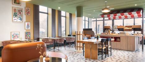 A modern restaurant with a bar area, seating arrangements, and artwork on the walls.