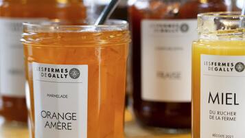 Zwei Gläser Marmelade und Honig mit Etiketten auf einer Holztischplatte.