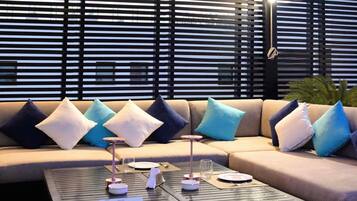 A modern lounge area with a sofa set, a coffee table with a 'RESERVED' sign, and a patterned backdrop.