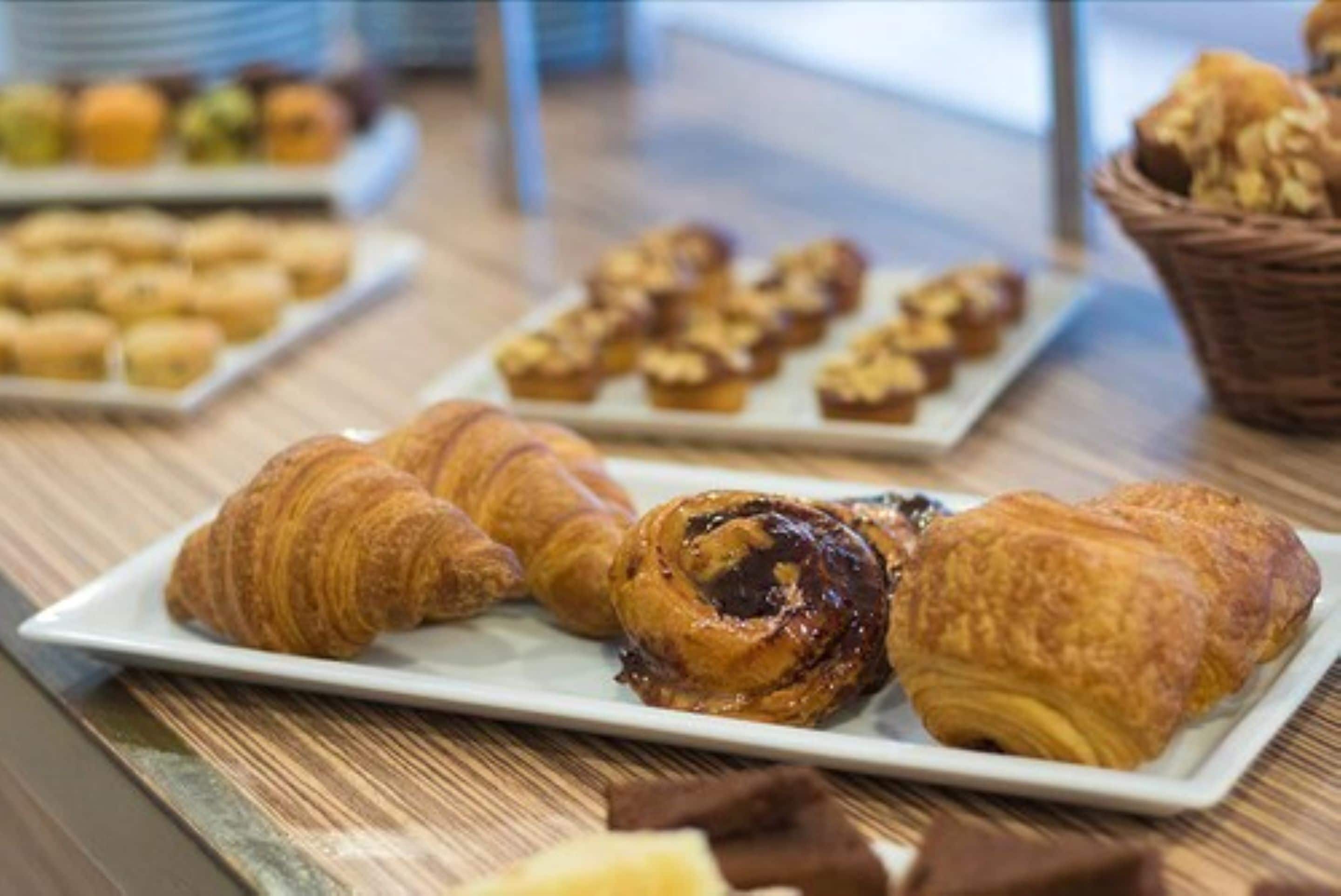 A table with pastries including croissants and muffins.