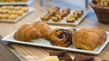 A table with pastries including croissants and muffins.