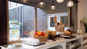 Un buffet per la colazione allestito con cesti di vimini, piatti e diverse varietà di cibo.