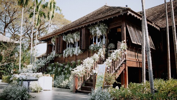 Un edificio tradizionale in legno con una scala e decorazioni floreali bianche.
