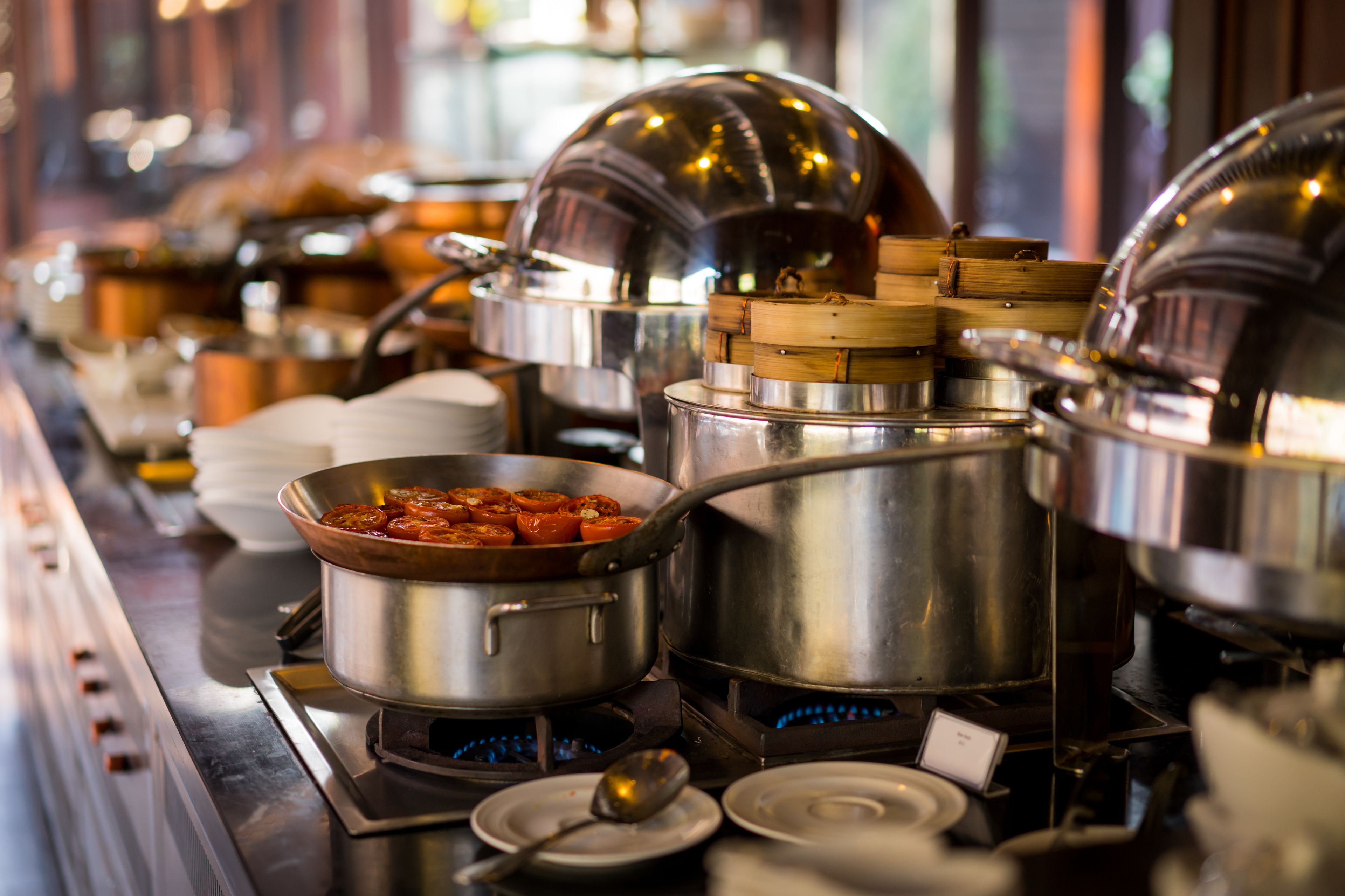 Uma mesa de buffet com diversos recipientes de comida e utensílios para servir.