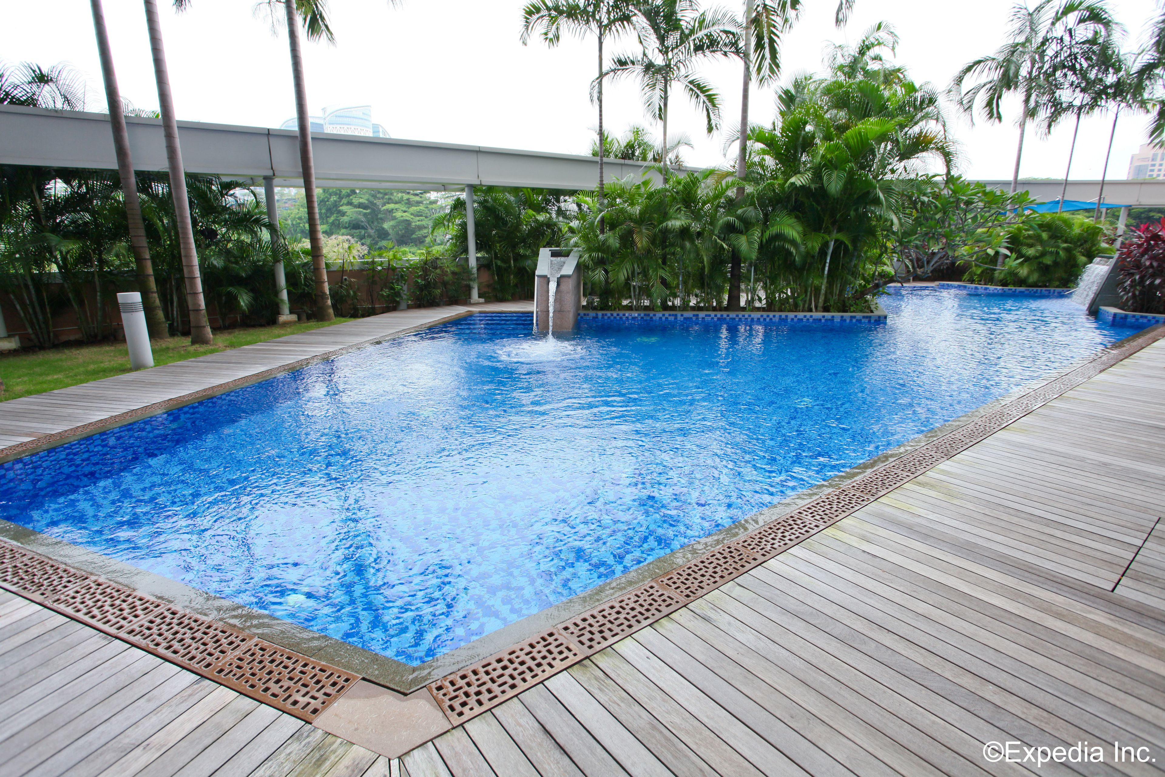 Una piscina al aire libre, sillones reclinables de piscina