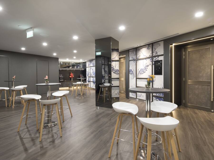 A modern interior with bar stools, tables, and a large wooden cabinet.