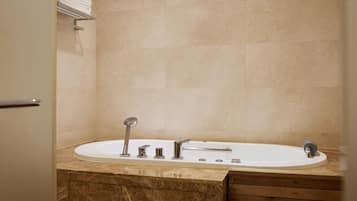 Un baño con una bañera, un tocador con espejo y un perchero para toallas.