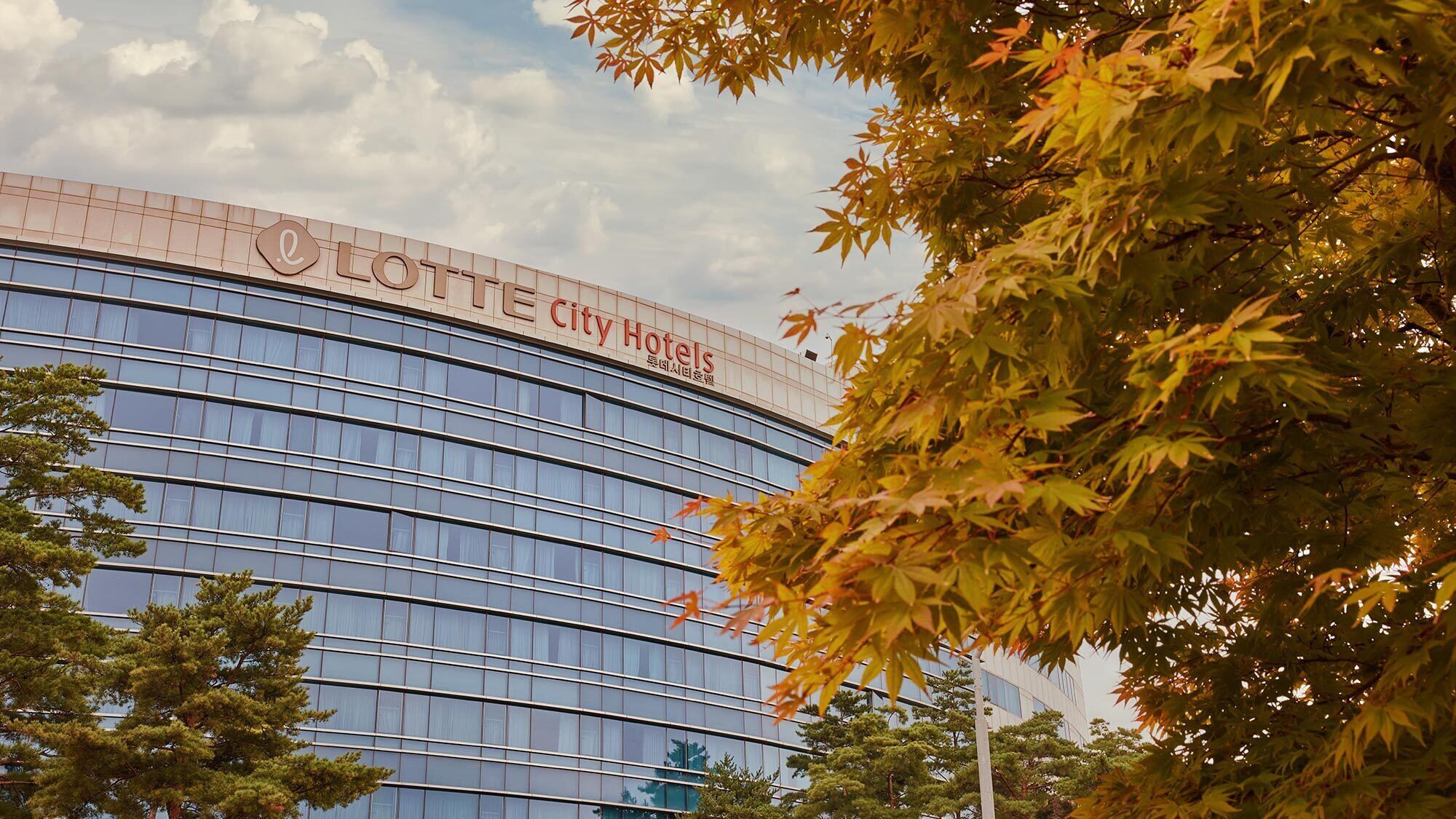A modern hotel building with a curved facade and large windows.