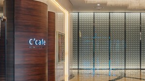 Een modern interieur met een houten kolom waarop 'Café' staat en een behang met patroon.