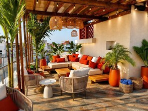 A rooftop terrace with a sofa set, wicker chairs, and potted plants. - NH Cartagena Urban Royal (Cartagena)