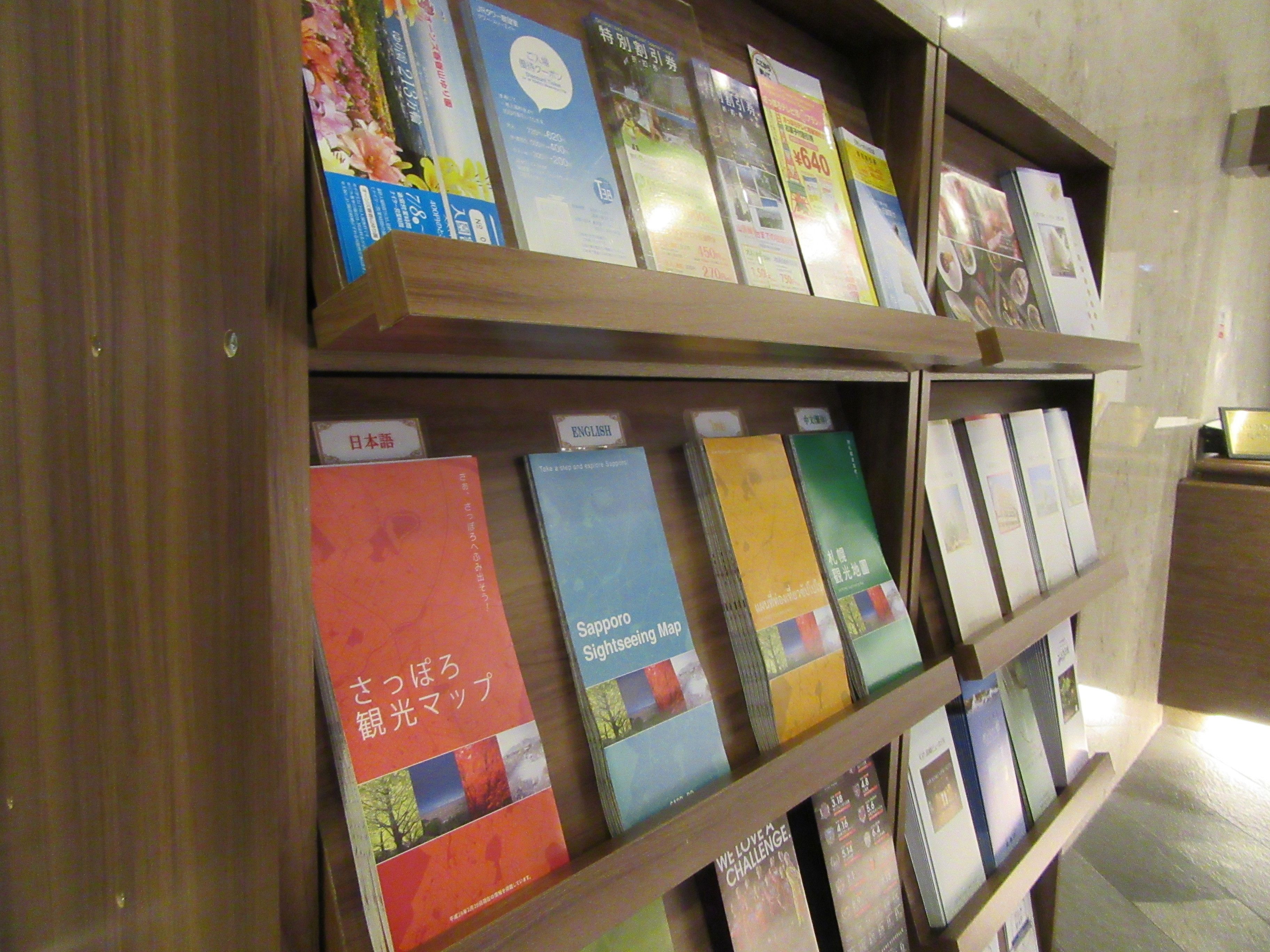 A bookshelf with various books and pamphlets, some labeled in Japanese.