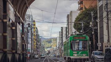 A tram on a city street with buildings and power lines.