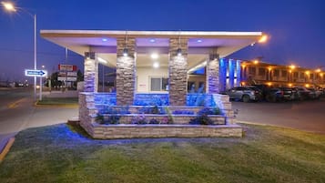 A gas station with a canopy, stone pillars, and a well-lit entrance.
