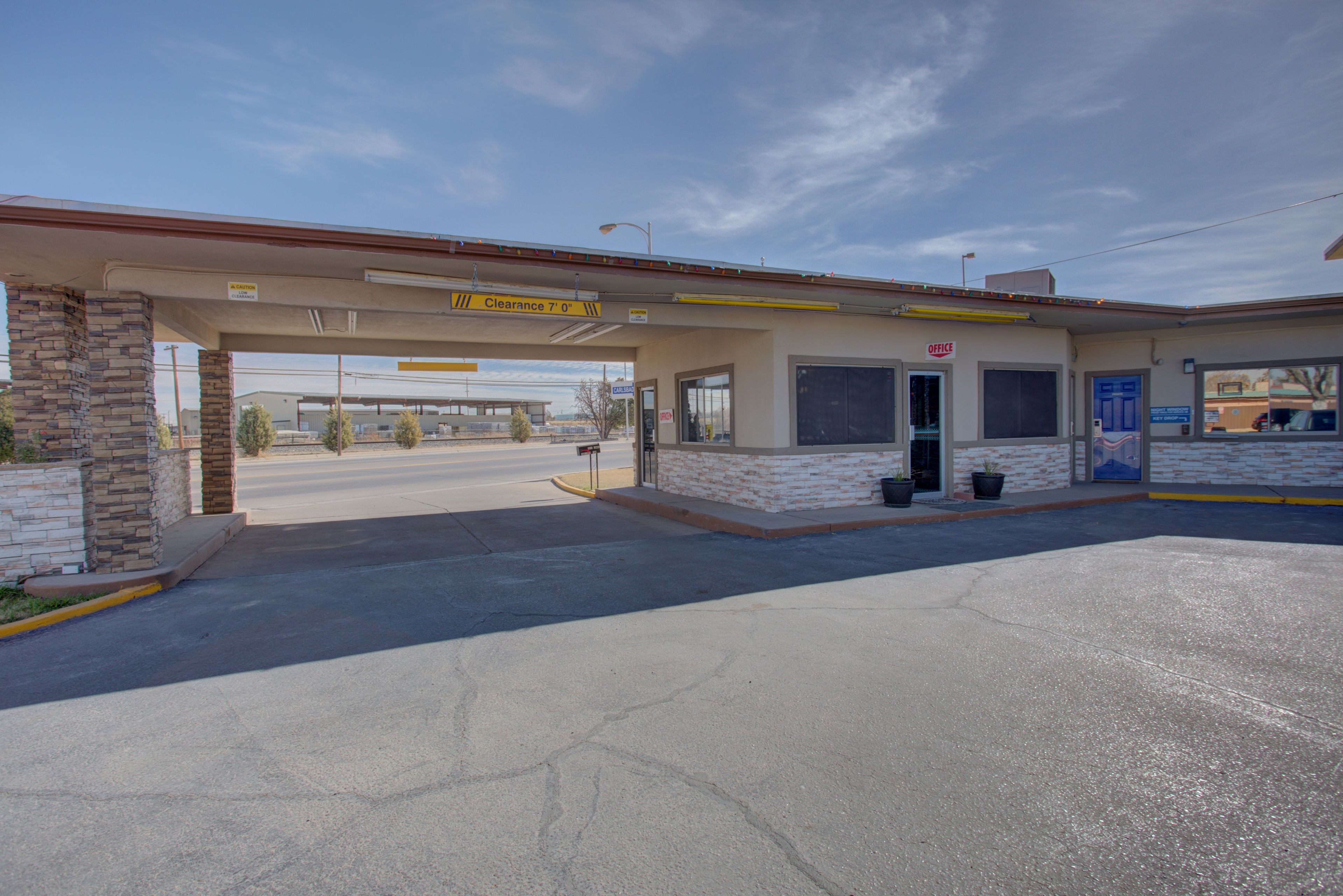 Une station-service avec un panneau indiquant une voie dégagée, une façade en briques et une seule entrée.