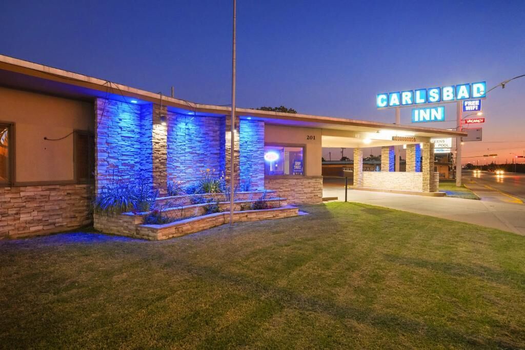 Un edificio con un letrero que dice 'CARLSBAD INN' de noche.