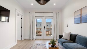 A modern living room with a sofa, a coffee table with a plant, and a patterned rug. - 27 On Park (Dahlonega)