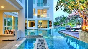 A modern hotel with a large indoor swimming pool, a lounge area with seating, and a well-lit interior. - Mida De Sea Hua Hin (Cha-am)
