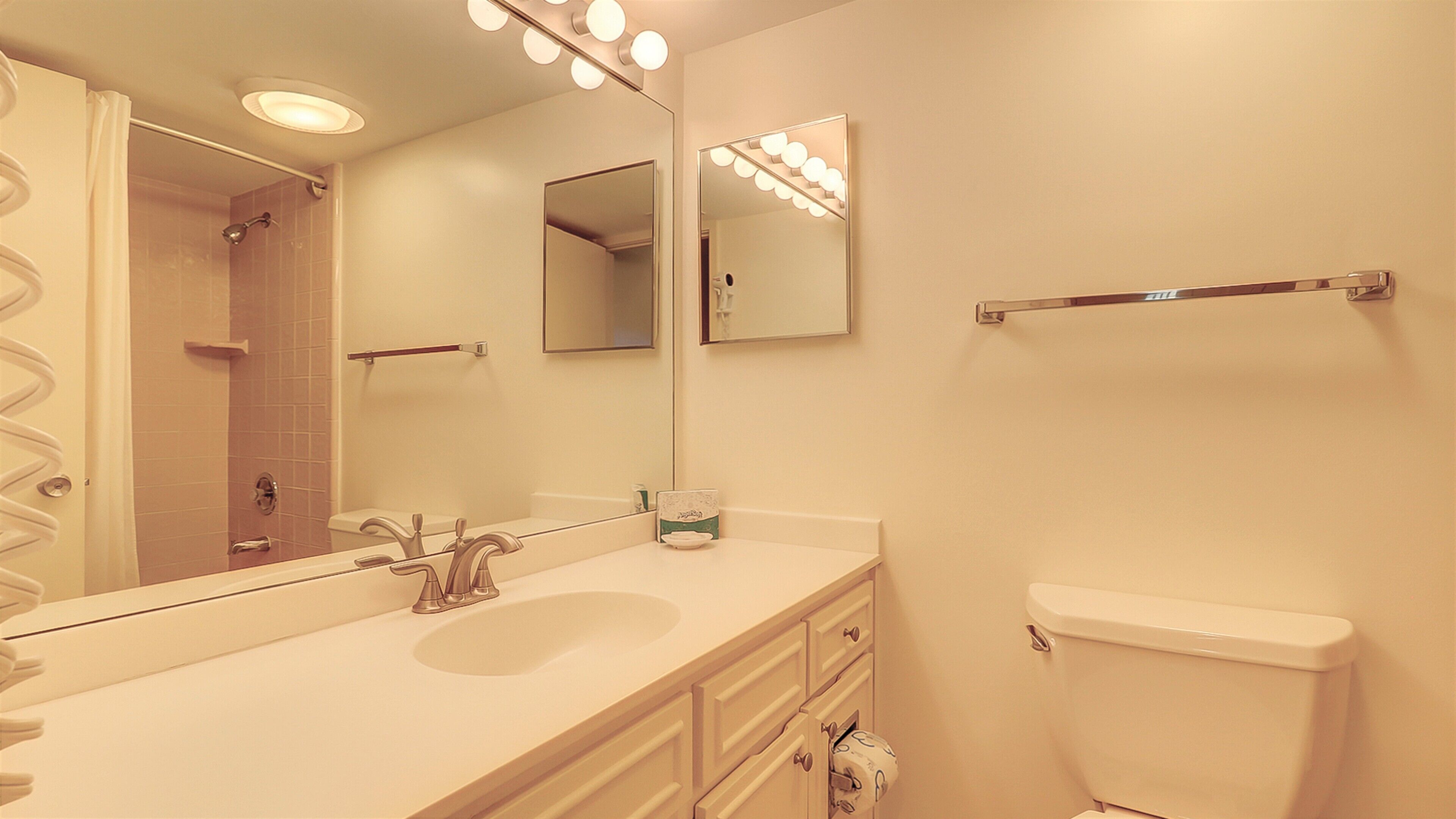 A bathroom with a sink, mirror, and toilet.
