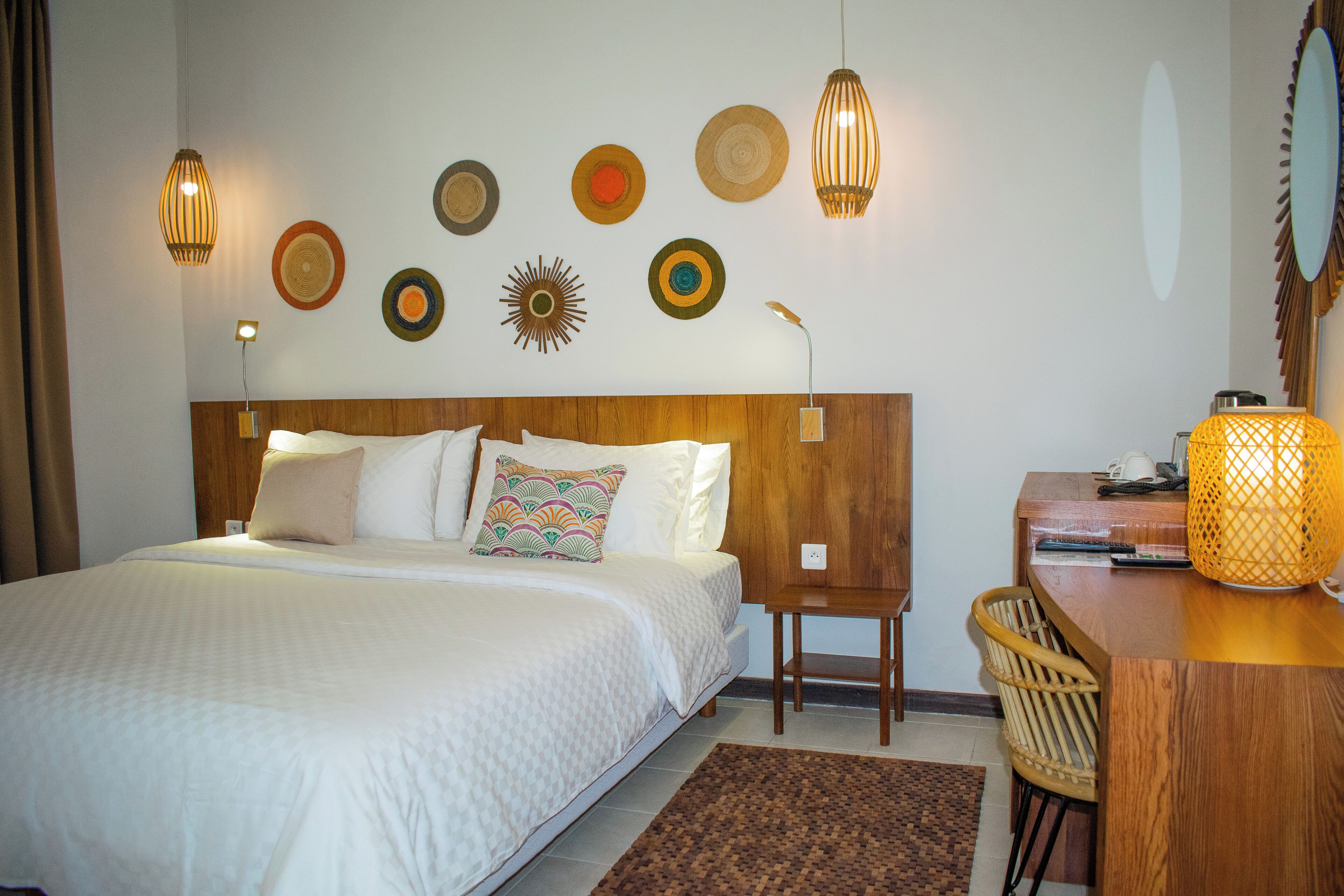 Una habitación de hotel con cama, mesita de noche, lámpara y decoración en la pared.