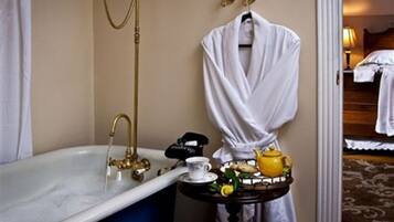 Ein Badezimmer mit einer Badewanne, einem Waschtisch mit Spiegel und einem Handtuchhalter.