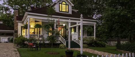 A two-story house with a porch, a staircase, and a front yard.