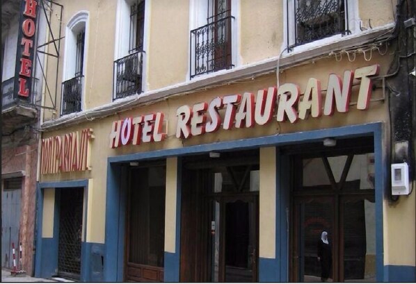 A hotel with a sign reading "HOTEL RESTAURANT" and a visible entrance.