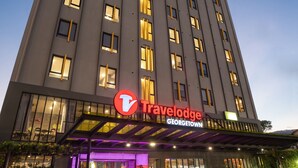 A tall building with a 'Travelodge' sign, indicating a hotel. - Travelodge Georgetown (George Town)