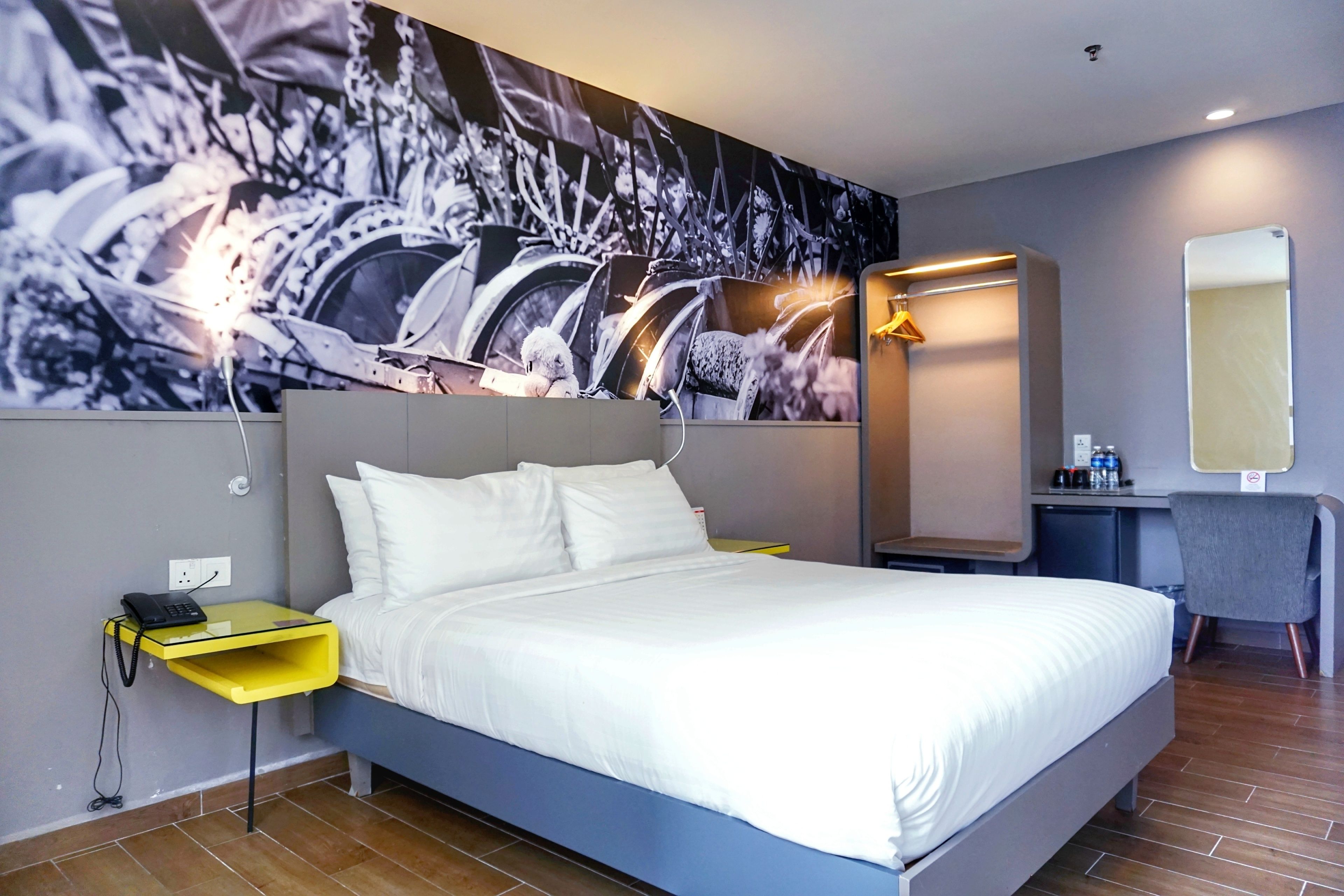 Una habitación de hotel moderna con una cama grande, un escritorio y una silla.