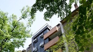 Un hotel de varios pisos con balcones, una entrada visible y un letrero que dice 'Hotel George'.